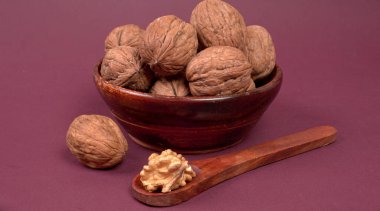 cevizler kasede ve ahşap kaşık mor arka planda