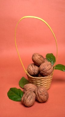 Turuncu arka planda sepetin içinde ceviz yığını