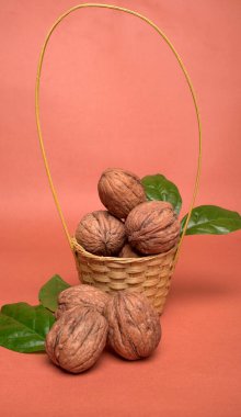 Turuncu arka planda sepetin içinde ceviz yığını