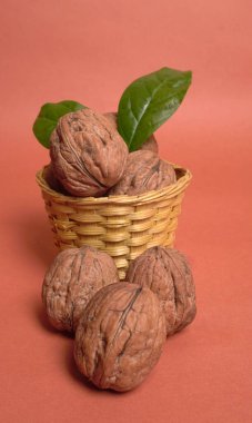 Turuncu arka planda sepetin içinde ceviz yığını