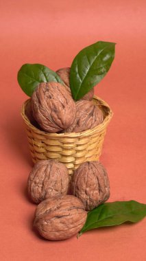 Turuncu arka planda sepetin içinde ceviz yığını