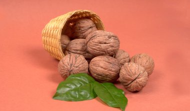 Turuncu arka planda sepetin içinde ceviz yığını