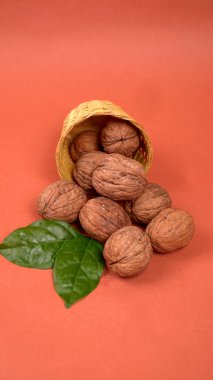 Turuncu arka planda sepetin içinde ceviz yığını