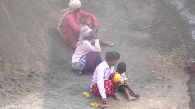 PUNE, MAHARASHTRA, INDIA 12 AĞUSTOS 2023: Yerlerde oturan ve dinlenen Hintli insanların üst görüntüsü