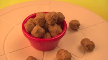 Ahşap bir arka planda plastik bir kasede çiğ soya parçaları. Sağlıklı, besleyici soya fasulyesi, kasede parçalar. Vejetaryen yemek görüntüsü.