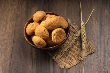 Tahta arka planda buğday ve çuval bezli ev yapımı kurabiyeler.