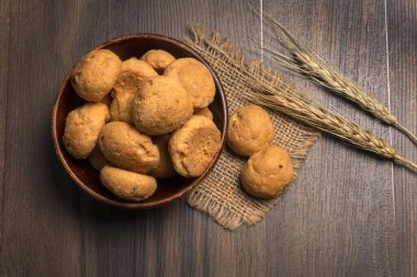 Tahta arka planda buğday ve çuval bezli ev yapımı kurabiyeler.