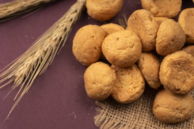 Mor arka planda buğday ve çuval bezli ev yapımı kurabiyeler.