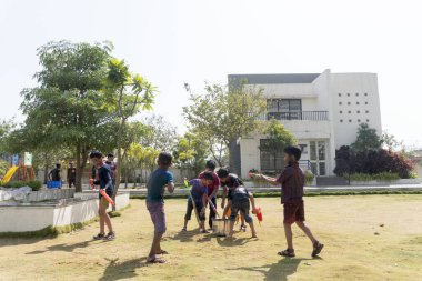 Pune Maharashtra Hindistan - 18 Mart 2022: Holi festivali sırasında renkli boyalarla oynayan Hintli çocuklar.