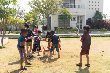 Pune Maharashtra Hindistan - 18 Mart 2022: Holi festivali sırasında renkli boyalarla oynayan Hintli çocuklar.