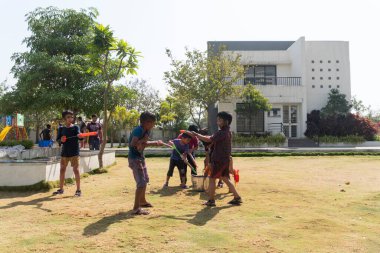 Pune Maharashtra Hindistan - 18 Mart 2022: Holi festivali sırasında renkli boyalarla oynayan Hintli çocuklar.