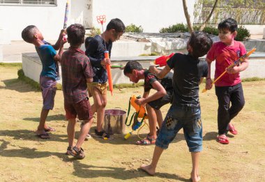 Pune Maharashtra Hindistan - 18 Mart 2022: Holi festivali sırasında renkli boyalarla oynayan Hintli çocuklar. 