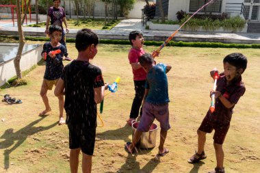 Pune Maharashtra, Hindistan - 18 Mart 2022: Holi festivali sırasında renkli boyalarla oynayan Hintli çocuklar.