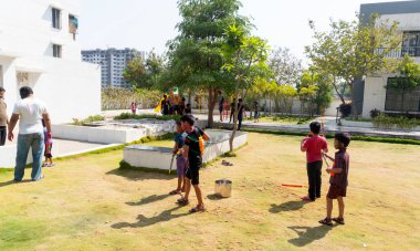 Pune Maharashtra, Hindistan - 18 Mart 2022: Holi festivali sırasında renkli boyalarla oynayan Hintli çocuklar.