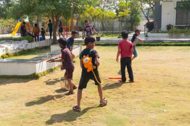 Pune Maharashtra, Hindistan - 18 Mart 2022: Holi festivali sırasında renkli boyalarla oynayan Hintli çocuklar.