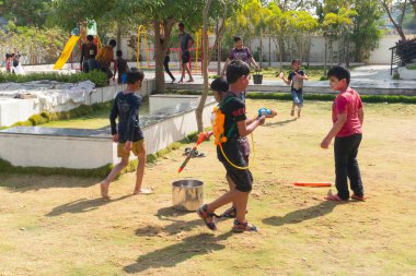 Pune Maharashtra, Hindistan - 18 Mart 2022: Holi festivali sırasında renkli boyalarla oynayan Hintli çocuklar.