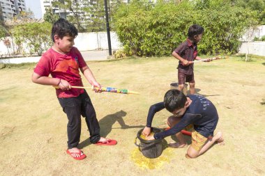 Pune Maharashtra, Hindistan - 18 Mart 2022: Holi festivali sırasında renkli boyalarla oynayan Hintli çocuklar.