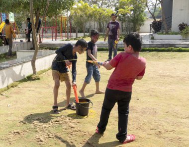 Pune Maharashtra, Hindistan - 18 Mart 2022: Holi festivali sırasında renkli boyalarla oynayan Hintli çocuklar.