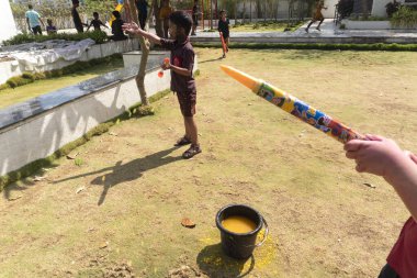 Pune Maharashtra, Hindistan - 18 Mart 2022: Holi festivali sırasında renkli boyalarla oynayan Hintli çocuklar.