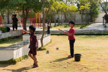 Pune Maharashtra, Hindistan - 18 Mart 2022: Holi festivali sırasında renkli boyalarla oynayan Hintli çocuklar.