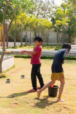 Pune Maharashtra, Hindistan - 18 Mart 2022: Holi festivali sırasında renkli boyalarla oynayan Hintli çocuklar.
