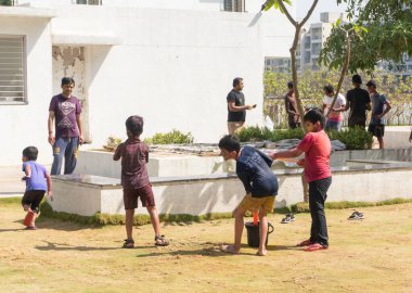 Pune Maharashtra, Hindistan - 18 Mart 2022: Holi festivali sırasında renkli boyalarla oynayan Hintli çocuklar.