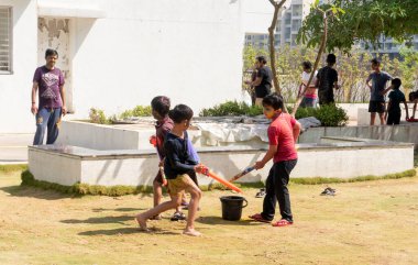 Pune Maharashtra, Hindistan - 18 Mart 2022: Holi festivali sırasında renkli boyalarla oynayan Hintli çocuklar.