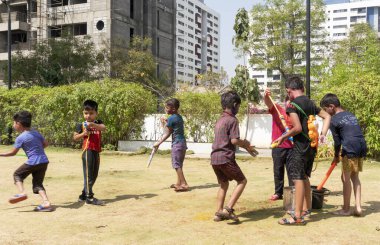 Pune Maharashtra, Hindistan - 18 Mart 2022: Holi festivali sırasında renkli boyalarla oynayan Hintli çocuklar.