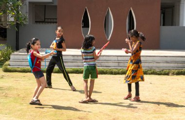 Pune Maharashtra, Hindistan - 18 Mart 2022: Holi festivali sırasında renkli boyalarla oynayan Hintli çocuklar.