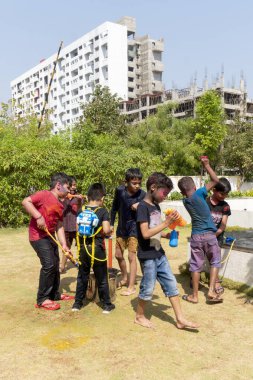 Pune Maharashtra, Hindistan - 18 Mart 2022: Holi festivali sırasında renkli boyalarla oynayan Hintli çocuklar.