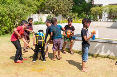 Pune Maharashtra, Hindistan - 18 Mart 2022: Holi festivali sırasında renkli boyalarla oynayan Hintli çocuklar.