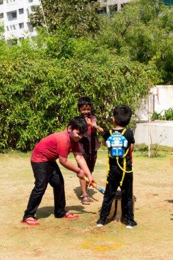 Pune Maharashtra, Hindistan - 18 Mart 2022: Holi festivali sırasında renkli boyalarla oynayan Hintli çocuklar.