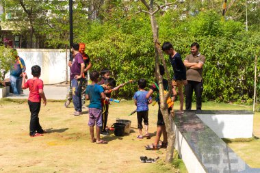 Pune Maharashtra, Hindistan - 18 Mart 2022: Holi festivali sırasında renkli boyalarla oynayan Hintli çocuklar.