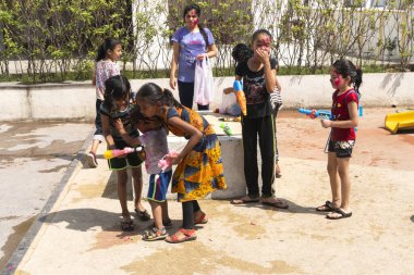 Pune Maharashtra, Hindistan - 18 Mart 2022: Holi festivali sırasında renkli boyalarla oynayan Hintli çocuklar.
