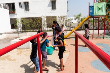 Pune Maharashtra, Hindistan - 18 Mart 2022: Holi festivali sırasında renkli boyalarla oynayan Hintli çocuklar.