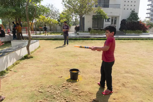Pune Maharashtra, Hindistan - 18 Mart 2022: Holi festivali sırasında renkli boyalarla oynayan Hintli çocuklar.