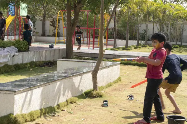 Pune Maharashtra, Hindistan - 18 Mart 2022: Holi festivali sırasında renkli boyalarla oynayan Hintli çocuklar.