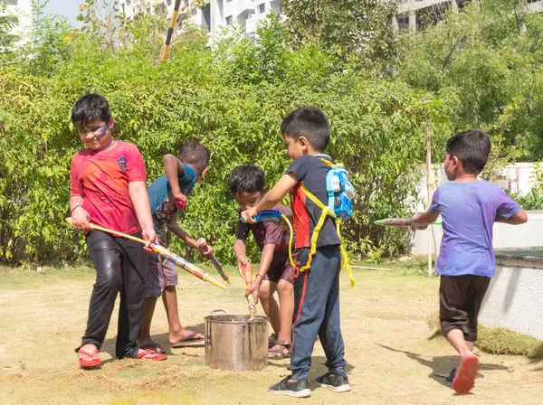 Pune Maharashtra, Hindistan - 18 Mart 2022: Holi festivali sırasında renkli boyalarla oynayan Hintli çocuklar.