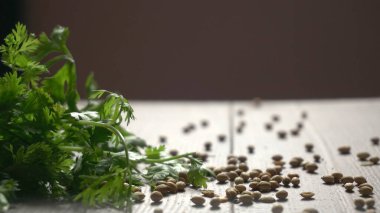 Kuru kişniş tohumları ile küçük bambu kaşığı ve yeşil taze kişniş yaprakları, Asya 'nın mutfağında bulunan ünlü baharatlar.