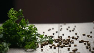 Kuru kişniş tohumları ile küçük bambu kaşığı ve yeşil taze kişniş yaprakları, Asya 'nın mutfağında bulunan ünlü baharatlar.