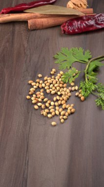 Kuru kişniş tohumları ile küçük bambu kaşığı ve yeşil taze kişniş yaprakları, Asya 'nın mutfağında bulunan ünlü baharatlar..