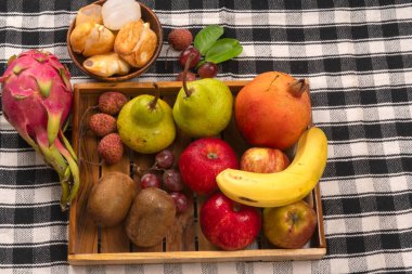 Ekose masa örtüsünün üzerindeki tahta kutuda tropik meyveler. 