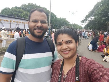 Pune, Maharashtra, India - 2 July 2024: Couple taking selfi during Pandharpur wari. Procession of Pilgrims marching towards Vitthala temple with singing religious songs with dancing. clipart