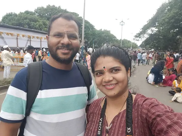 stock image Pune, Maharashtra, India - 2 July 2024: Couple taking selfi during Pandharpur wari. Procession of Pilgrims marching towards Vitthala temple with singing religious songs with dancing.