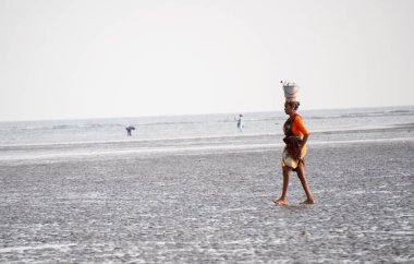 ALIBAG, MAHARASHTRA, INDIA - 25 Mart 2024: Kolaba Kalesi yakınlarındaki Alibag plajında kimliği belirsiz turist.