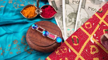 Geleneksel Hint Bilekliği Rakhi, Kardeş Bağları Kardeşler Bileğinde Raksha Bandhan Ocassion. Bilezik, kırmızı ve sarı baharatlar, Hint paraları. 