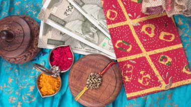 Geleneksel Hint Bilekliği Rakhi, Kardeş Bağları Kardeşler Bileğinde Raksha Bandhan Ocassion. Bilezik, kırmızı ve sarı baharatlar, Hint paraları. 