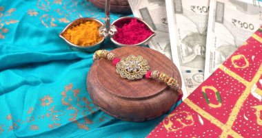 Geleneksel Hint Bilekliği Rakhi, Kardeş Bağları Kardeşler Bileğinde Raksha Bandhan Ocassion. Bilezik, kırmızı ve sarı baharatlar, Hint paraları. 