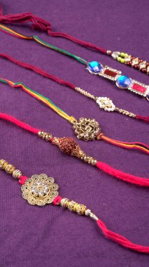 Geleneksel Hint bileklikleri mor arka planda Rakhi, Kardeş Bağları Kardeşler Bileğinde Raksha Bandhan