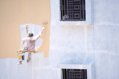 Endüstriyel dağcı duvarları boyarken ipte sallanıyor 